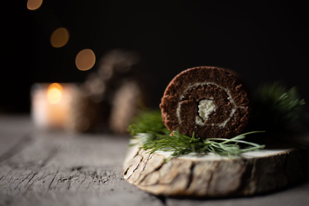 Un gros plan d'un roulé au chocolat sur un plateau en bois rustique, parfait pour les amateurs de desserts.