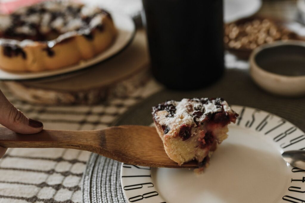 Gros plan sur une part de gâteau aux cerises fraîchement cuit sur une assiette, parfait pour le dessert ou une pause café sucrée.