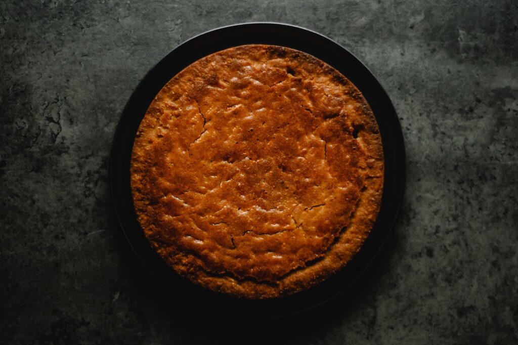 Un délicieux gâteau aux carottes fait maison sur une assiette noire, parfait pour les amateurs de desserts.