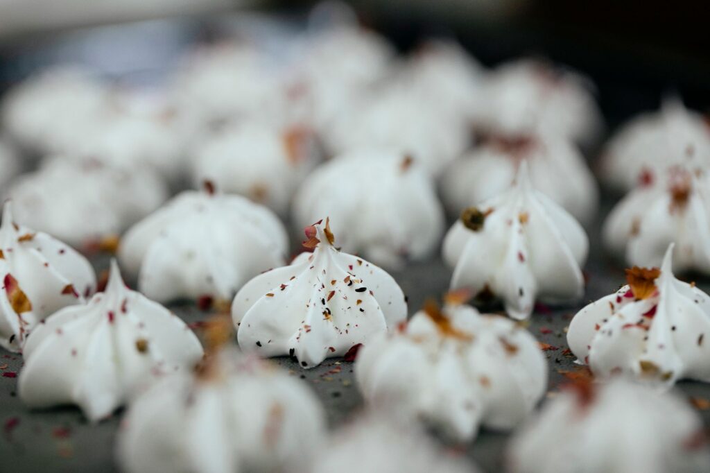 Gros plan sur des meringues fraîchement cuites saupoudrées d'épices, parfaites pour les amateurs de dessert.