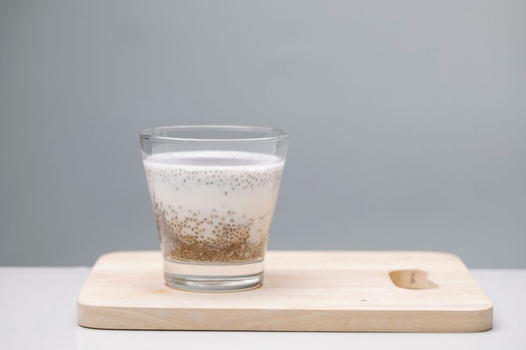 Un pudding savoureux aux graines de chia dans un verre sur une planche en bois, parfait pour une collation saine.