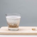 Un pudding savoureux aux graines de chia dans un verre sur une planche en bois, parfait pour une collation saine.