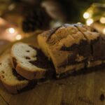 De délicieuses tranches de gâteau marbré sur une planche à découper en bois festive avec des lumières de vacances chaleureuses.