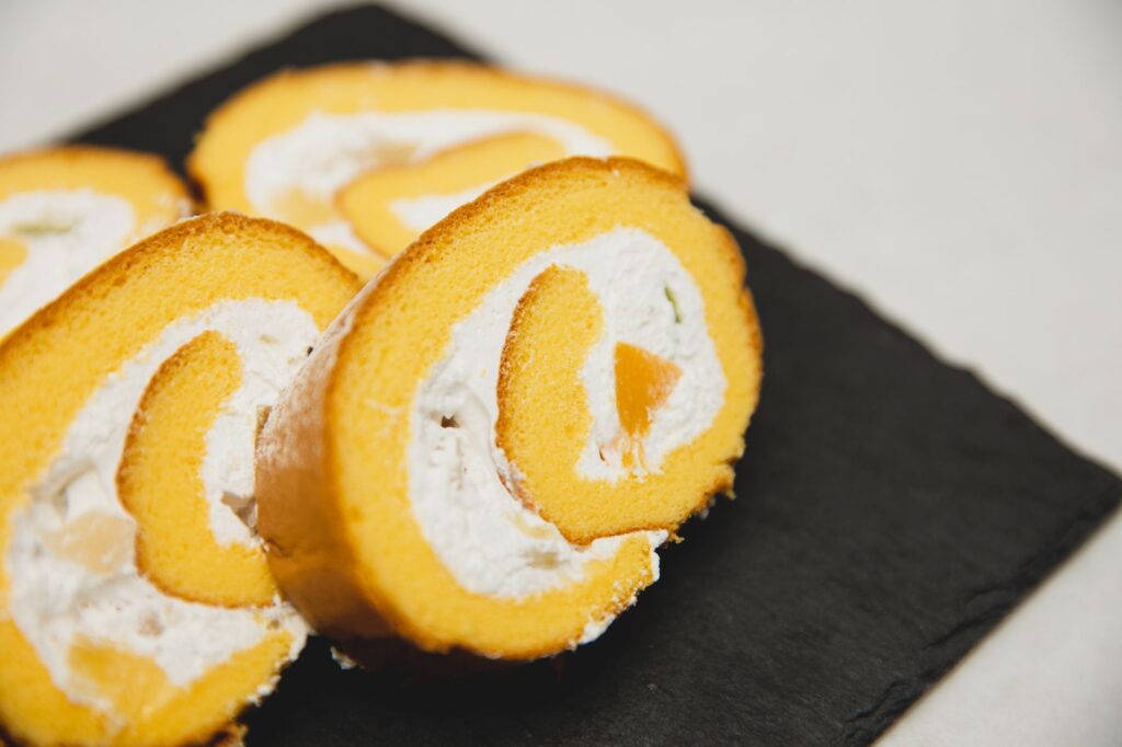 Gros plan sur des tranches de gâteau roulé suisse délicieuses sur une planche en ardoise. Photographie de dessert parfaite.