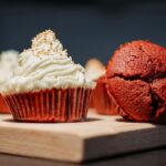 Gros plan de délicieux cupcakes en velours rouge sur une planche en bois.