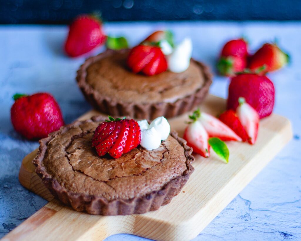 Satisfaites vos envies sucrées avec cette tarte au chocolat ornée de fraises fraîches et de crème.