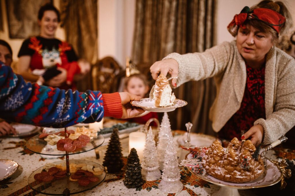 Rassemblement familial festif de Noël avec partage de gâteau, atmosphère joyeuse des fêtes.
