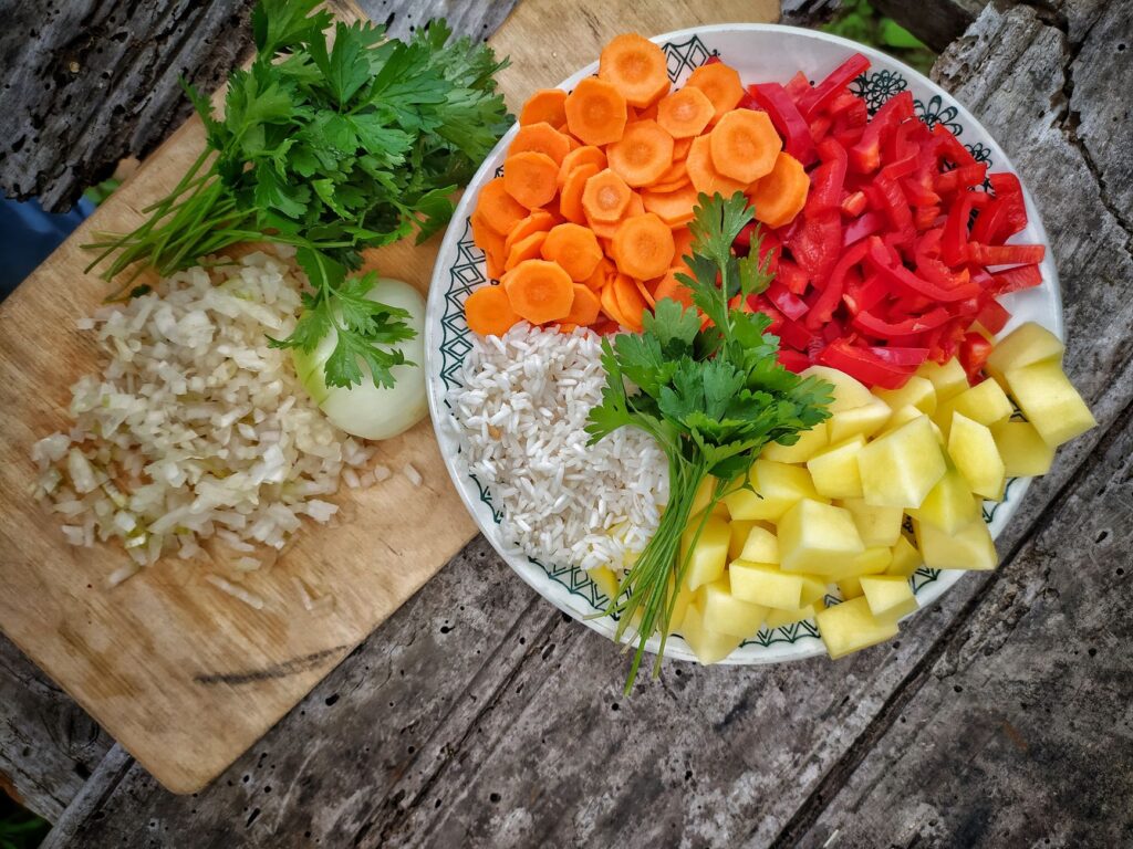Un assortiment coloré de légumes frais et de riz disposés sur une table en bois rustique.