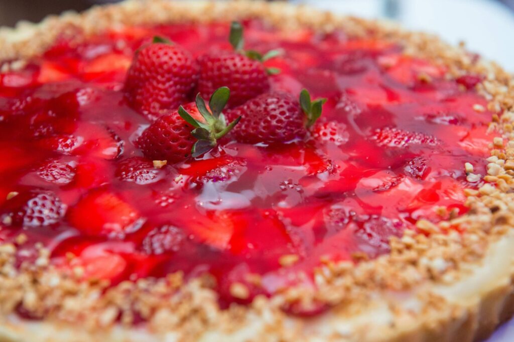 Gros plan sur un délicieux cheesecake surmonté de fraises fraîches et d'un glaçage en gelée.