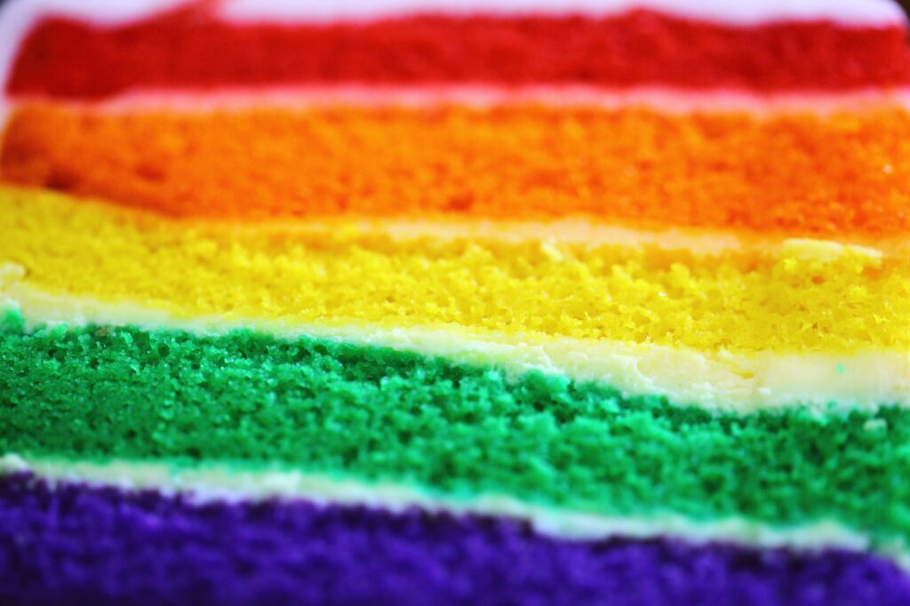 Vue détaillée d'un gâteau en couches coloré arc-en-ciel, parfait pour les célébrations.