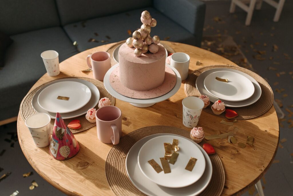 Un élégant gâteau d'anniversaire rose avec des décorations sur une table festive.