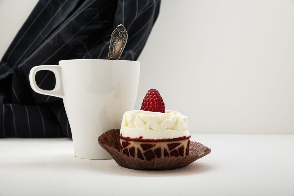 Un délicieux gâteau garni de framboises avec une tasse de café sur une table.