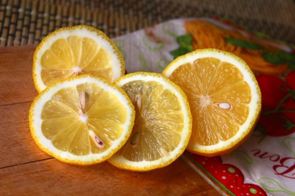 Gros plan de tranches de citron juteuses sur une planche en bois, mettant en valeur leur texture vibrante et leur fraîcheur.