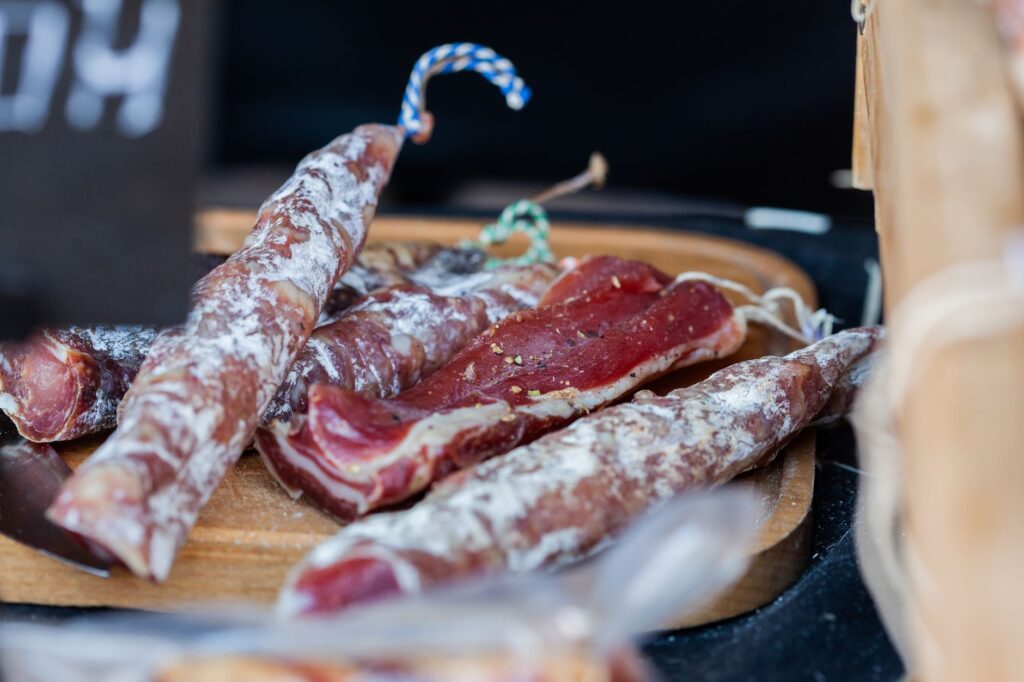 Assortiment délicieux de viandes séchées présenté sur un plateau en bois rustique, parfait pour la cuisine gourmet.