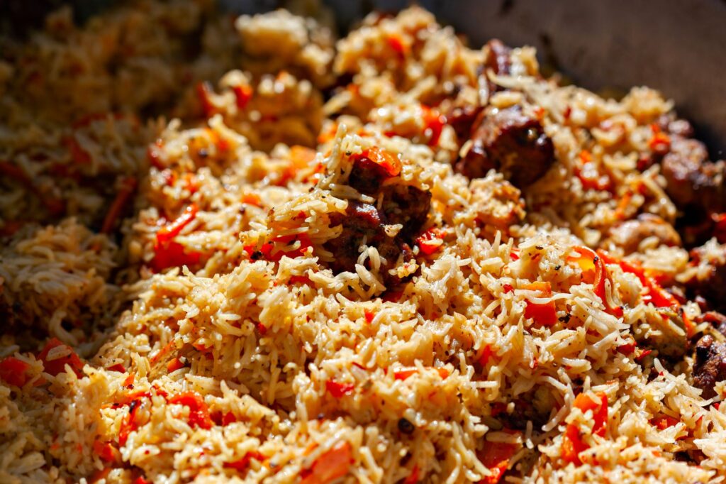 Gros plan alléchant d'un délicieux plat de biryani avec des épices et des tomates.