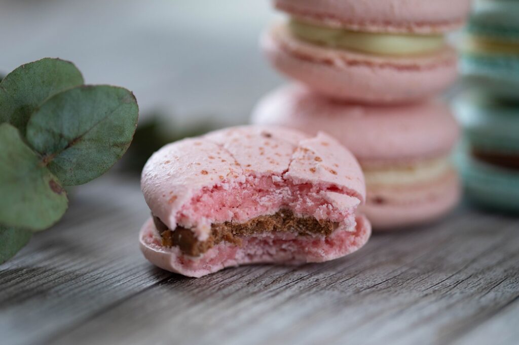Gros plan esthétique de macarons avec une bouchée, mettant en valeur les textures et les couleurs.