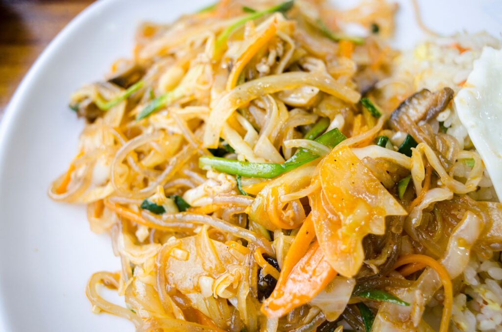 Des nouilles sautées appétissantes avec des légumes dans une assiette, parfaites pour une idée de repas délicieuse.