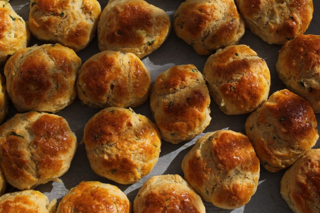 Délicieux biscuits dorés fraîchement cuits, disposés sur un plateau sous un éclairage chaleureux.