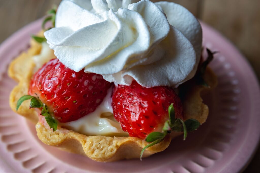 Savourez ce gros plan d'une tarte aux fraises garnie de crème chantilly fraîche.