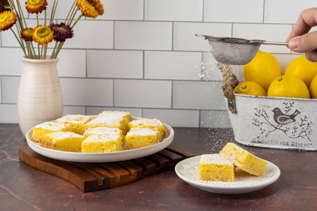 Des barres au citron fraîchement cuites saupoudrées de sucre glace, parfaites pour les desserts.
