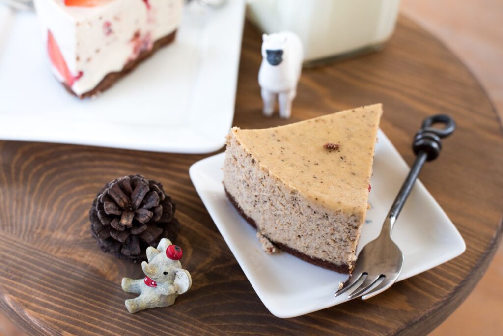 Vue du dessus d'une part de cheesecake avec des figurines sur une table en bois, parfait pour les amateurs de desserts.