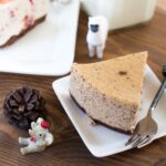 Vue du dessus d'une part de cheesecake avec des figurines sur une table en bois, parfait pour les amateurs de desserts.