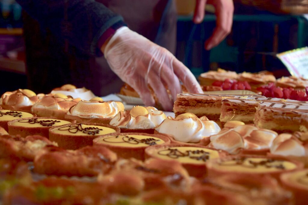 Délicieuses pâtisseries assorties comprenant des parts de crème et des meringues dans un stand de marché à Londres.