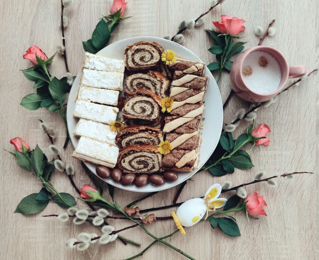 Vue de dessus de desserts de Pâques sur une assiette avec du café et des fleurs de printemps pour une ambiance festive.