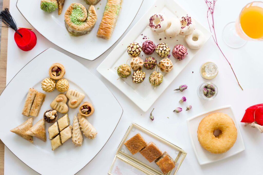 Une variété de pâtisseries et de douceurs délicieuses présentées élégamment sur des assiettes blanches.