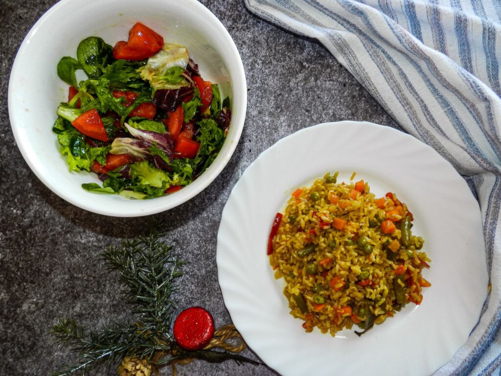Salade colorée et riz aux légumes sur une table, parfait pour un repas nutritif.