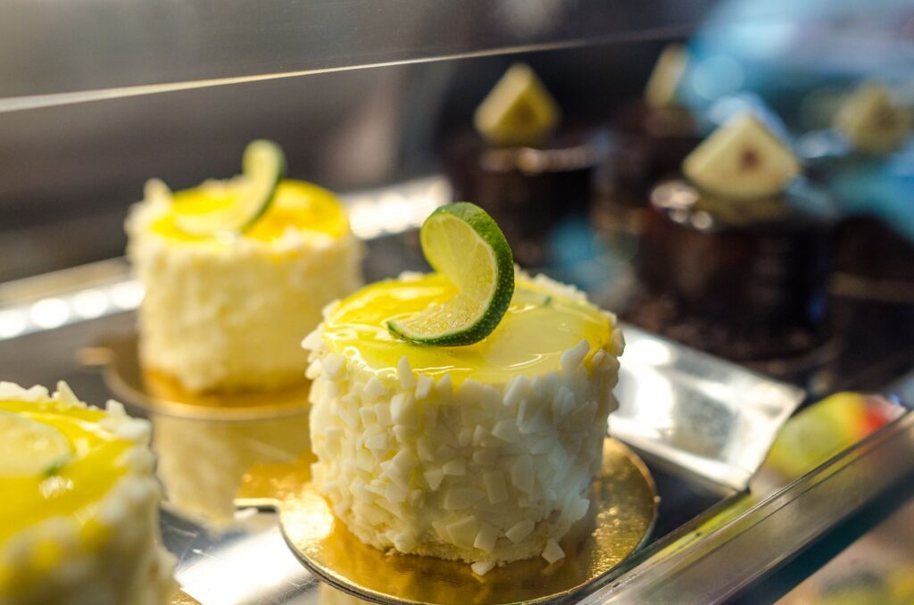 Délicieux gâteaux décorés de citron vert et de chocolat blanc sur un présentoir à pâtisseries.