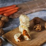 Délicieuses sucreries à la carotte au chocolat blanc sur une planche en bois rustique avec des noix.