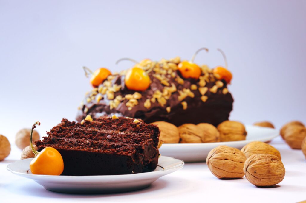 Gros plan d'une tranche de gâteau au chocolat avec des noix et des cerises, parfait pour les amateurs de desserts.