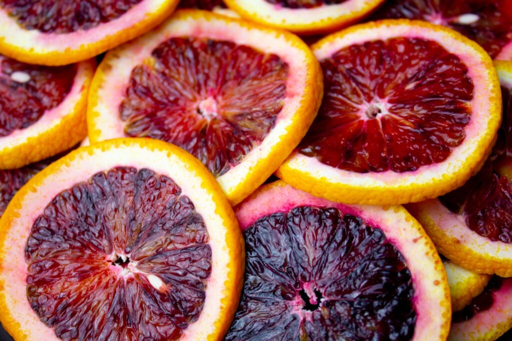 Gros plan de tranches d'oranges sanguines, mettant en valeur leurs couleurs vibrantes et leur texture juteuse.