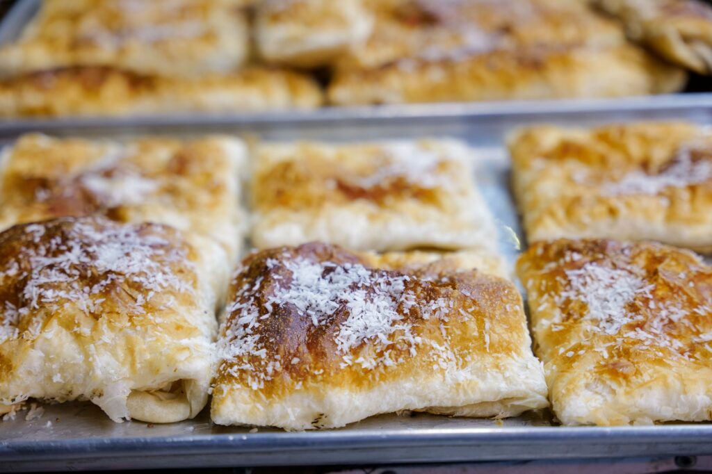 Des pâtisseries à la noix de coco dorées et fraîchement cuites sur un plateau, idéales pour les amateurs de desserts.