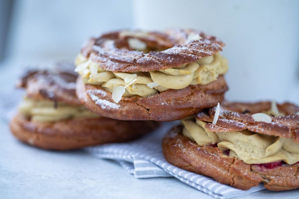 Délicieuse pâtisserie Paris-Brest garnie de riche crème, saupoudrée de sucre.