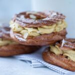 Délicieuse pâtisserie Paris-Brest garnie de riche crème, saupoudrée de sucre.