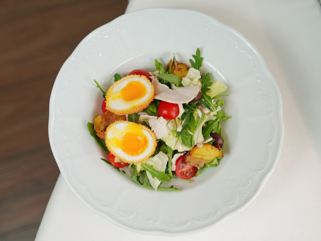 Délicieuse salade mixte avec des œufs mollets, des tomates et des légumes. Parfaite pour un déjeuner frais.
