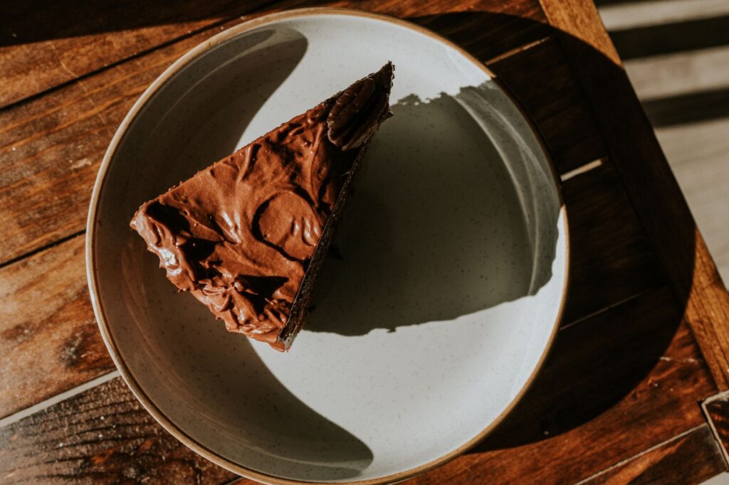 Part de gâteau au chocolat appétissante sur une table en bois rustique, parfaite pour des thèmes de dessert.