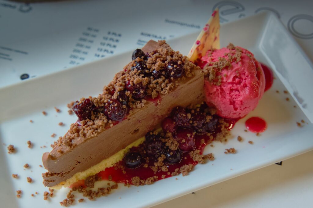 Délicieuse mousse au chocolat surmontée de baies et d'une boule de sorbet à la framboise.