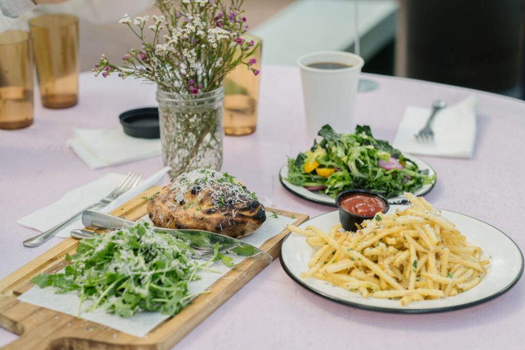 Profitez d'un repas gourmet avec une salade, des frites et du pain en plein air par une journée d'été.