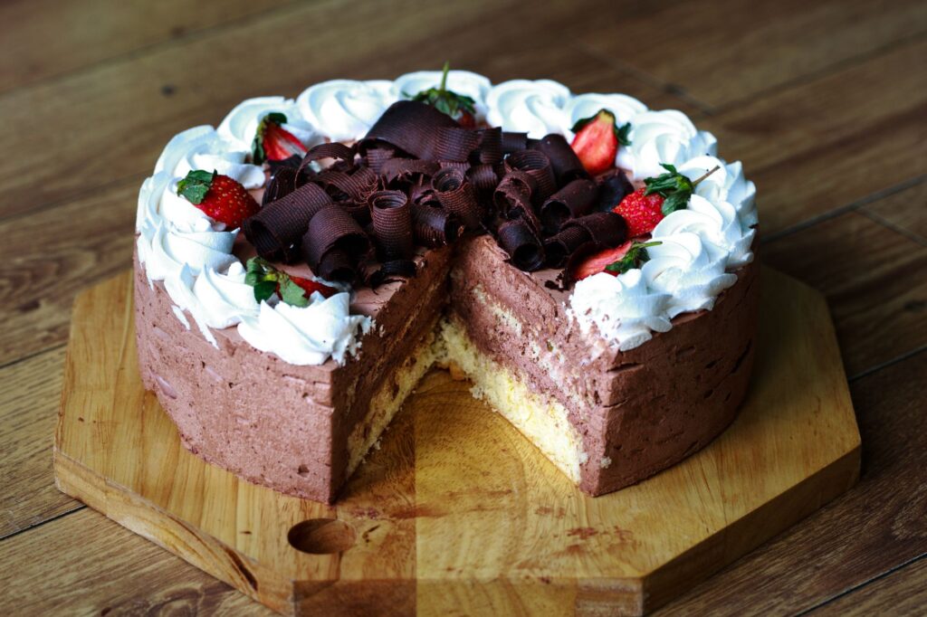 Un gâteau au chocolat visuellement séduisant, garni de fraises et de crème, parfait pour les desserts et les célébrations.