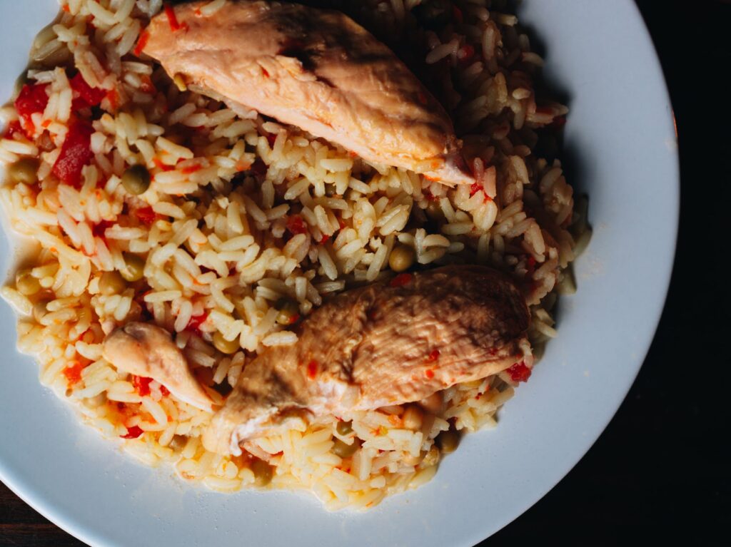 Plat appétissant de poulet et de riz servi dans une assiette blanche, capturé de haut.