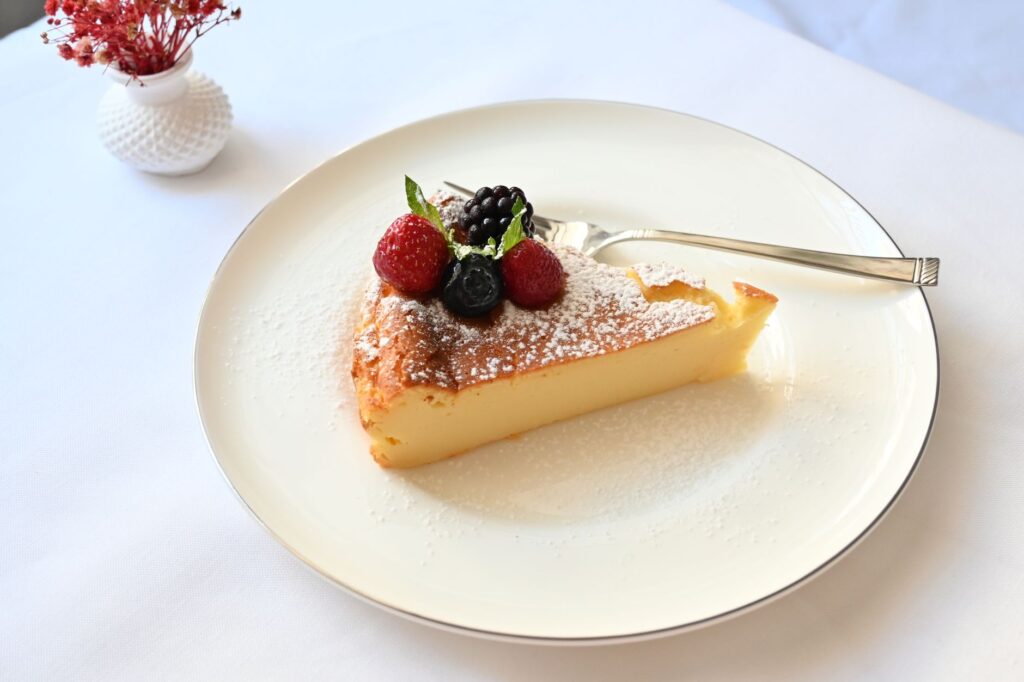 Une part de cheesecake tentante avec des baies fraîches sur une assiette blanche, parfaite pour le dessert.