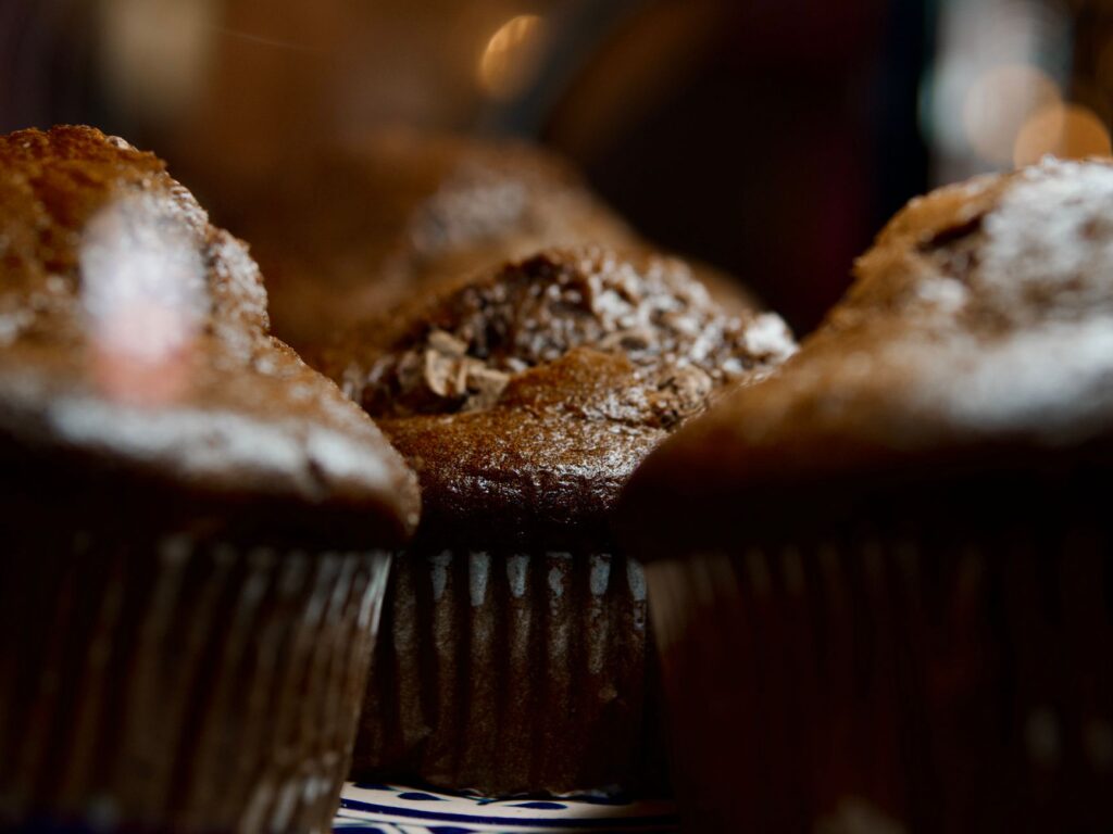 Délicieux muffins au chocolat capturés dans une ambiance chaleureuse, évoquant une douce gourmandise.