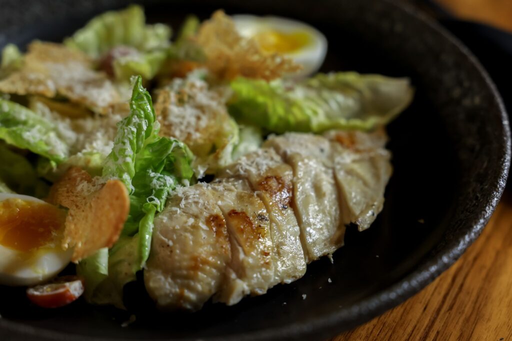 Une savoureuse salade César garnie de poulet grillé et d'œufs durs.
