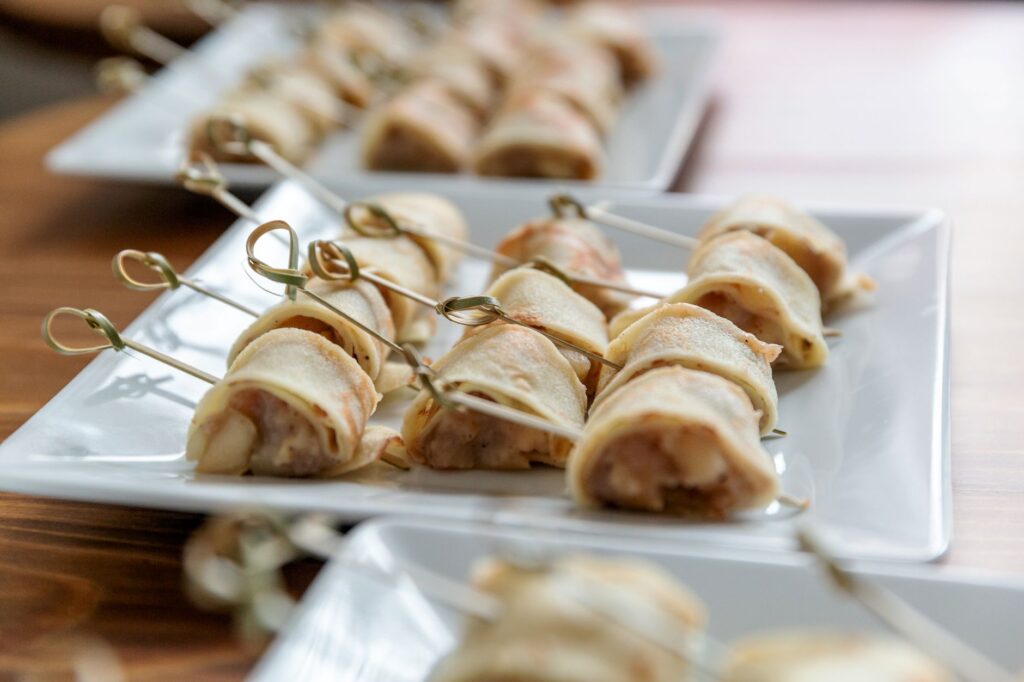 Amuse-bouches roulés délicatement sur des brochettes, parfaits pour les événements.