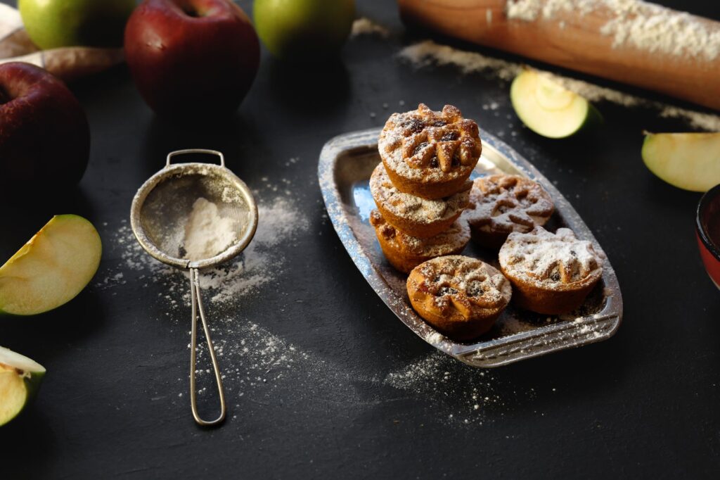 Délicieuses mini tartes aux pommes maison saupoudrées de sucre, parfaites pour un dessert réconfortant.