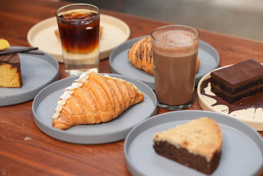 Une variété de délicieuses pâtisseries et boissons dans des assiettes, parfaites pour une expérience de café chaleureuse.