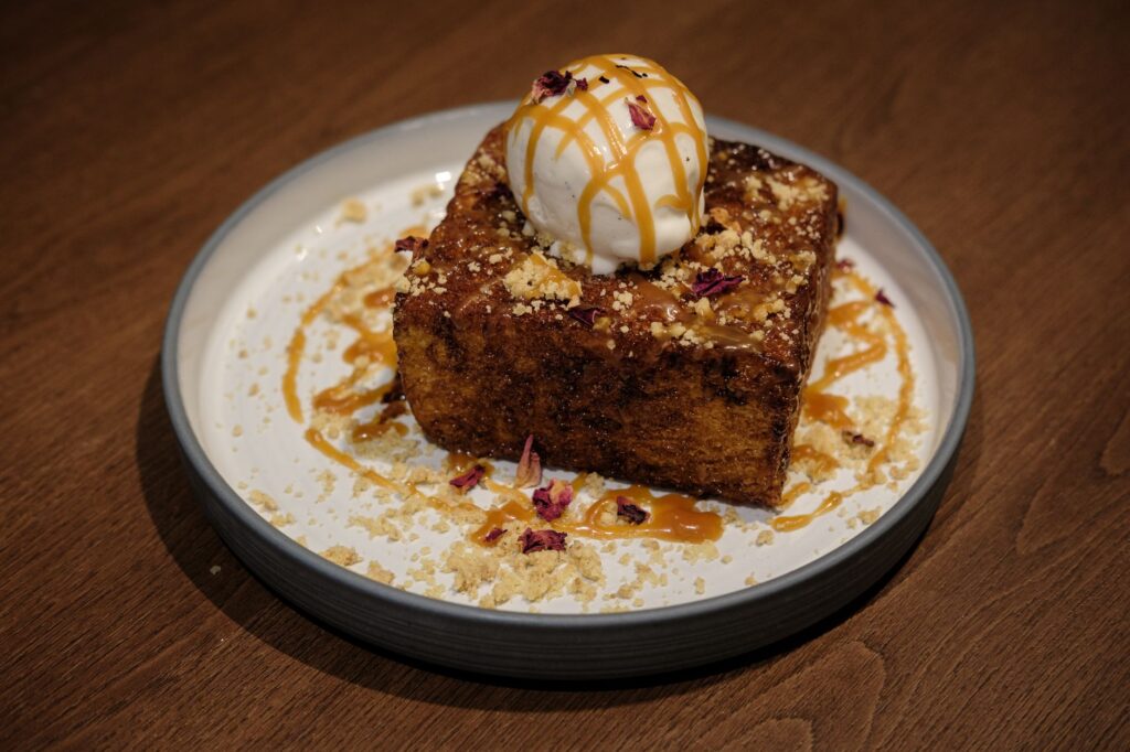 Délicieux pain perdu surmonté de glace et de caramel, décoré de pétales de rose et de miettes à Mumbai.